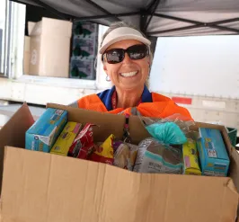 Woman holding box of food donations