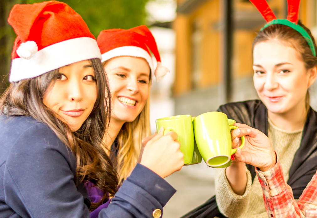 women in Santa hats with coffee mugs