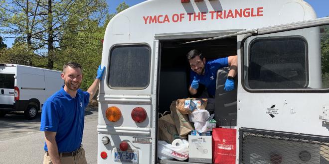YMCA staff loading food on a bus