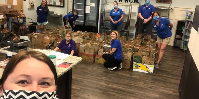 YMCA staff filing boxes with donated food