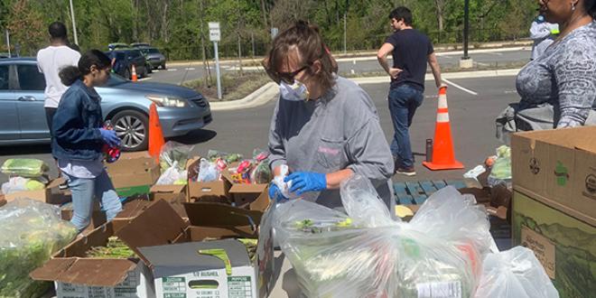 a YMCA volunteer boxes up lettuce at a local food drive