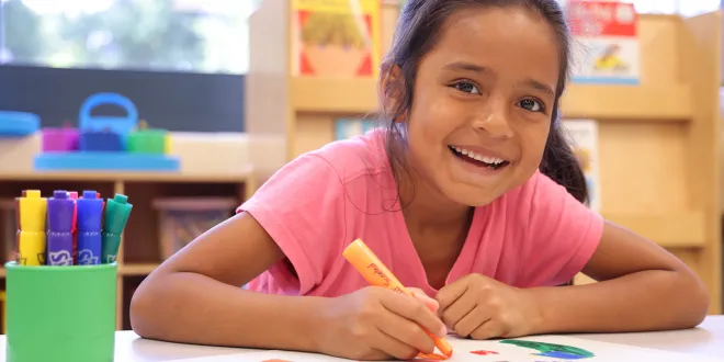 Girl working on art project at a table.