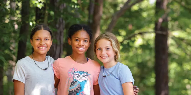 three young campers smiling at YMCA camp