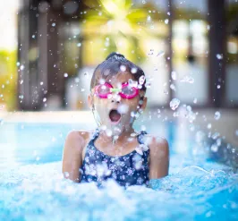 young girl splashing into pool