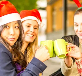 women in Santa hats with coffee mugs