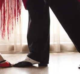 The heels and shoes of a pair of dancers doing the cha cha
