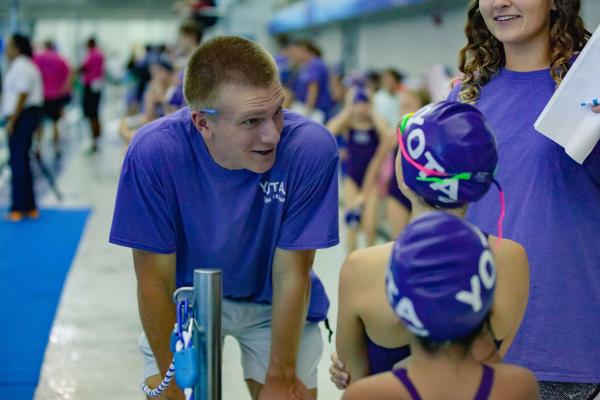 swim team coach giving advice to swimmers
