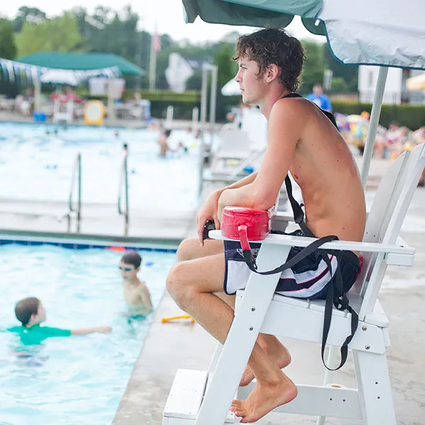 Lifeguard in chair beside the pool