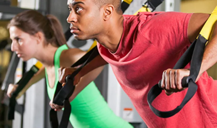 Man and woman using TRX machine at the YMCA