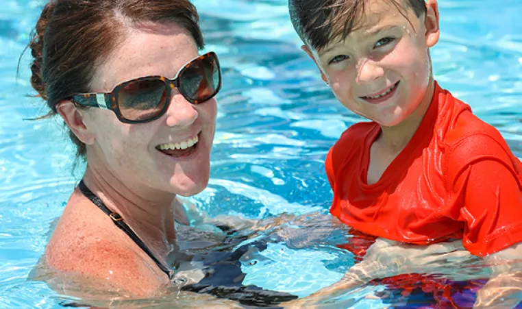 Mom and son swimming in pool