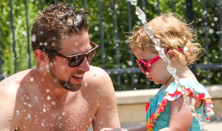 Dad and daughter on spray ground