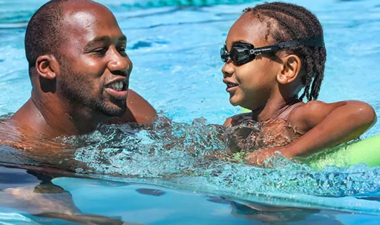 Young boy swimming with YMCA instructor