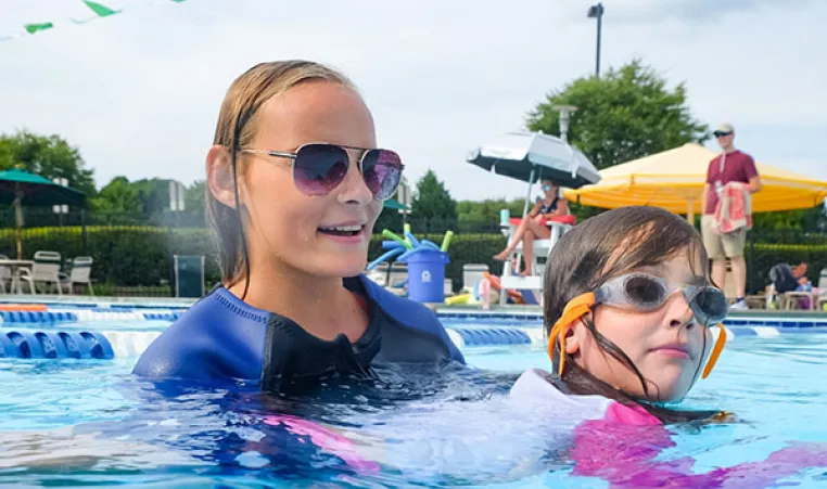 Young girl swimming with YMCA instructor