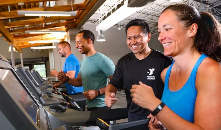 Woman on treadmill with personal trainer