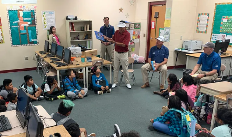 Golfers reading to students