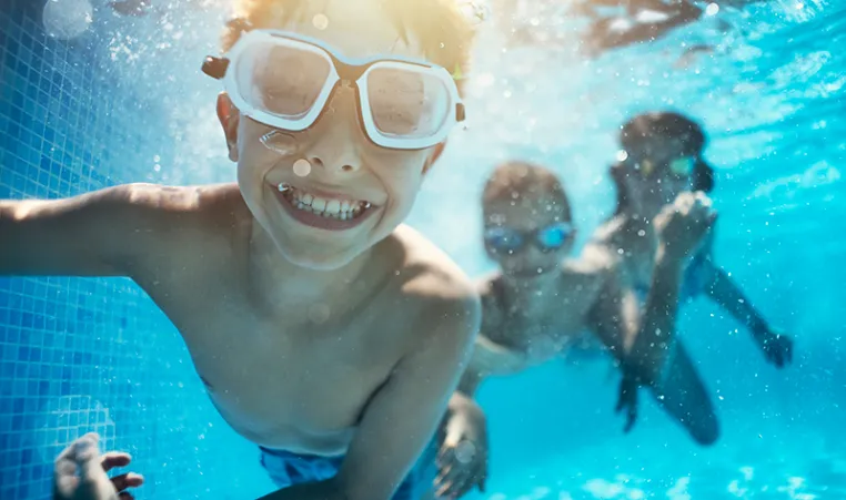 Boy smiling and swimming undewater