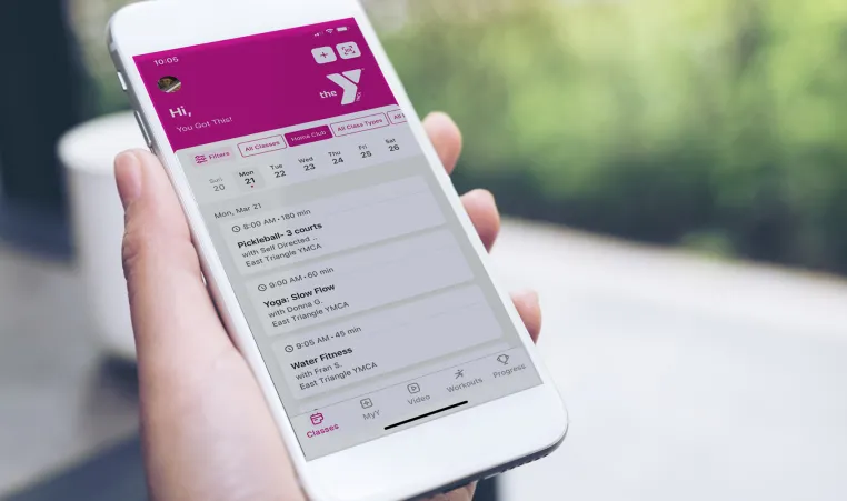 person holding YMCA mobile app on their phone