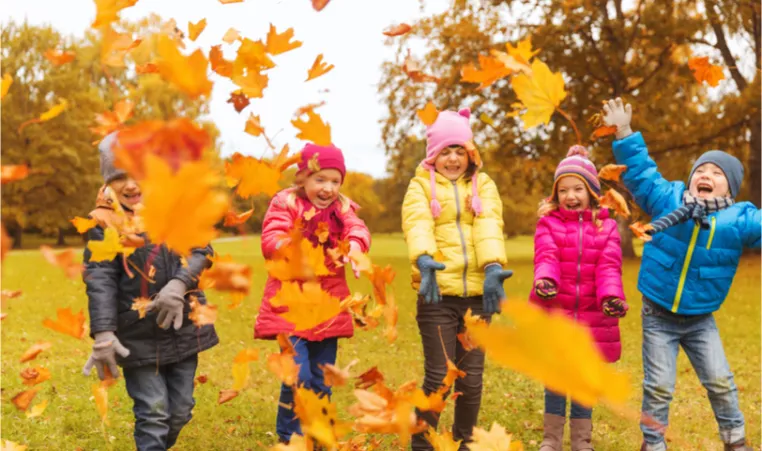 kids playing in fall leaves