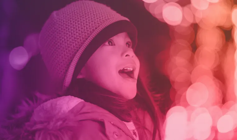 smiling child looking at holiday lights