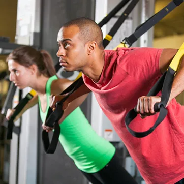 Man and woman using TRX machine at the YMCA