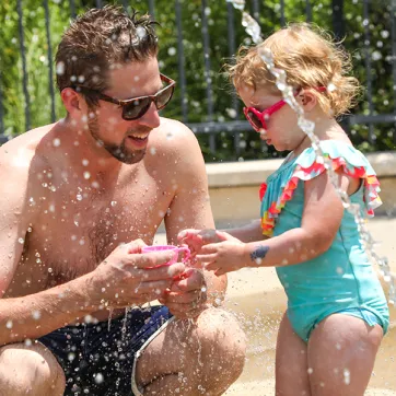 Dad and daughter on spray ground
