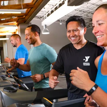 Woman on treadmill with personal trainer