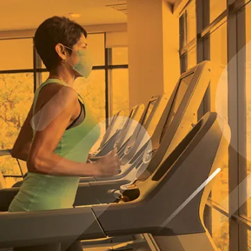 woman running on a treadmill wearing a mask at a YMCA