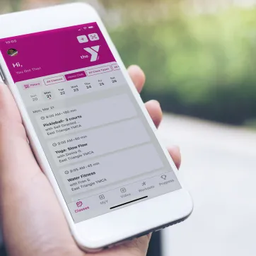 person holding YMCA mobile app on their phone