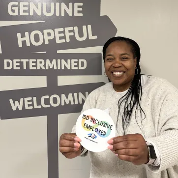 ymca staff member holds inclusive employer recognition sticker