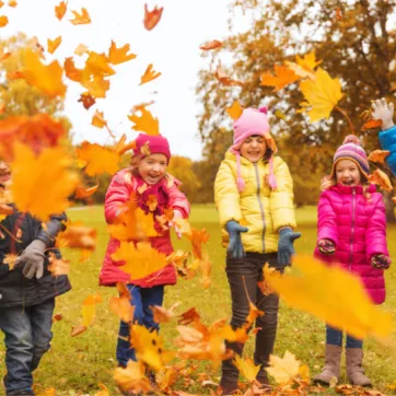 kids playing in fall leaves