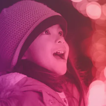 smiling child looking at holiday lights
