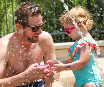Dad and daughter on spray ground