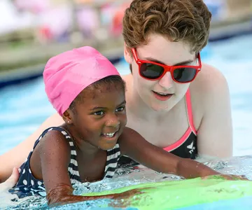 Young girl swimming with YMCA instructor
