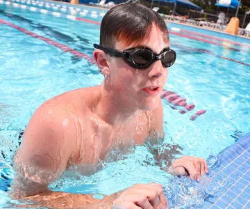 Young boy standing inside pool