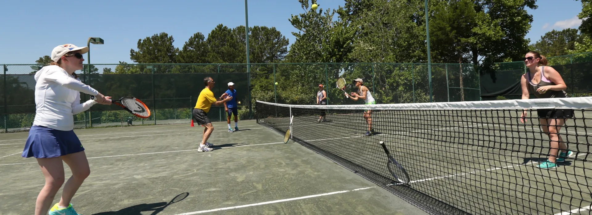 People playing tennis on Hope Valley Farms YMCA clay courts
